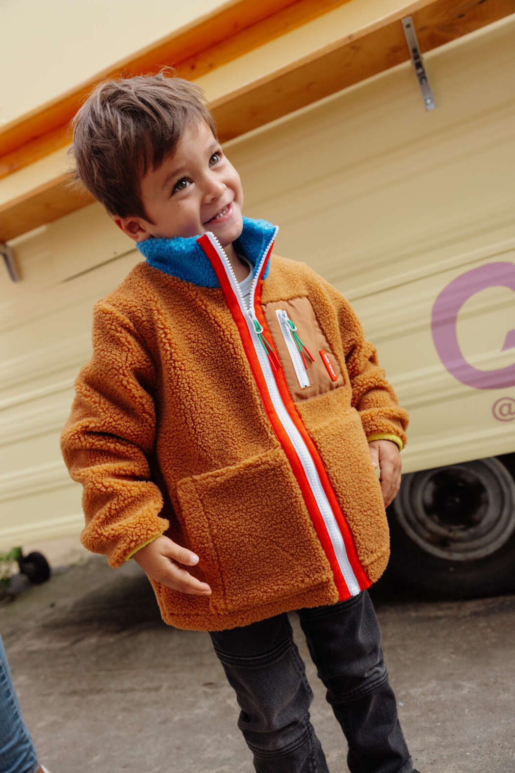 Kind draagt Hello Hossy teddyjas met opstaande kraag en ritszakken