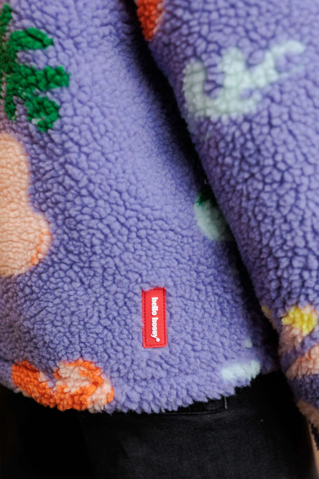 Kind draagt Floral Hello Hossy teddyjas met lila bloemenprint detail en fleece