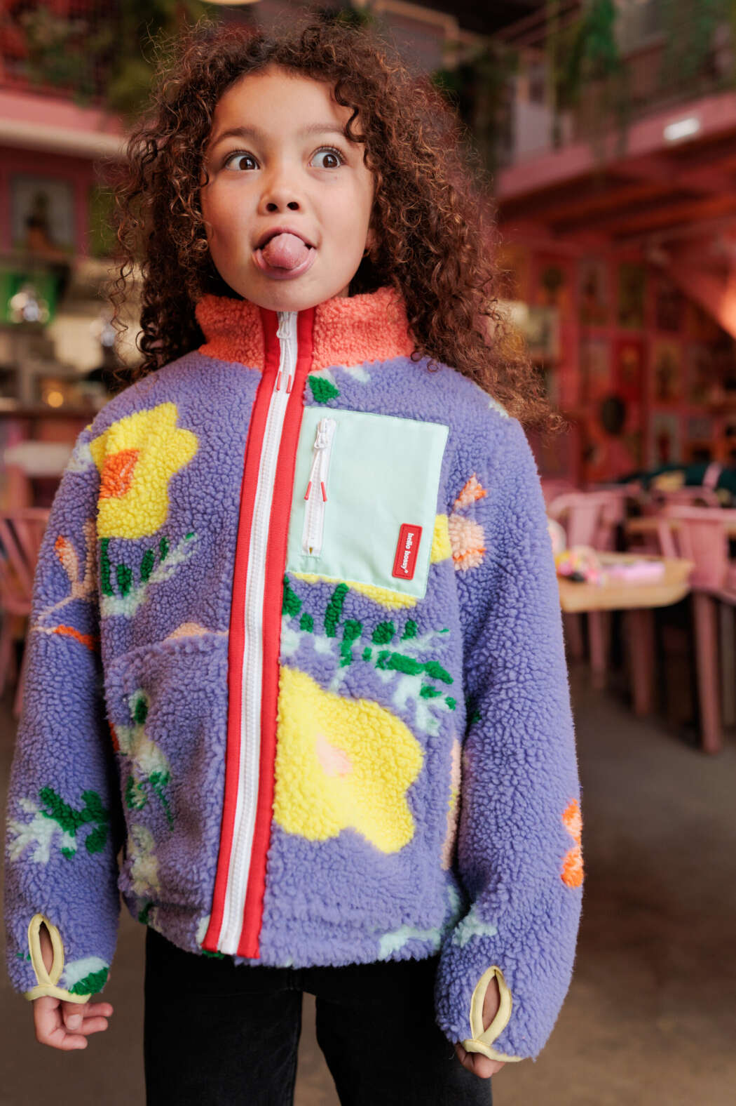 Kind draagt Floral Hello Hossy teddyjas met lila bloemenprint en kleurrijk