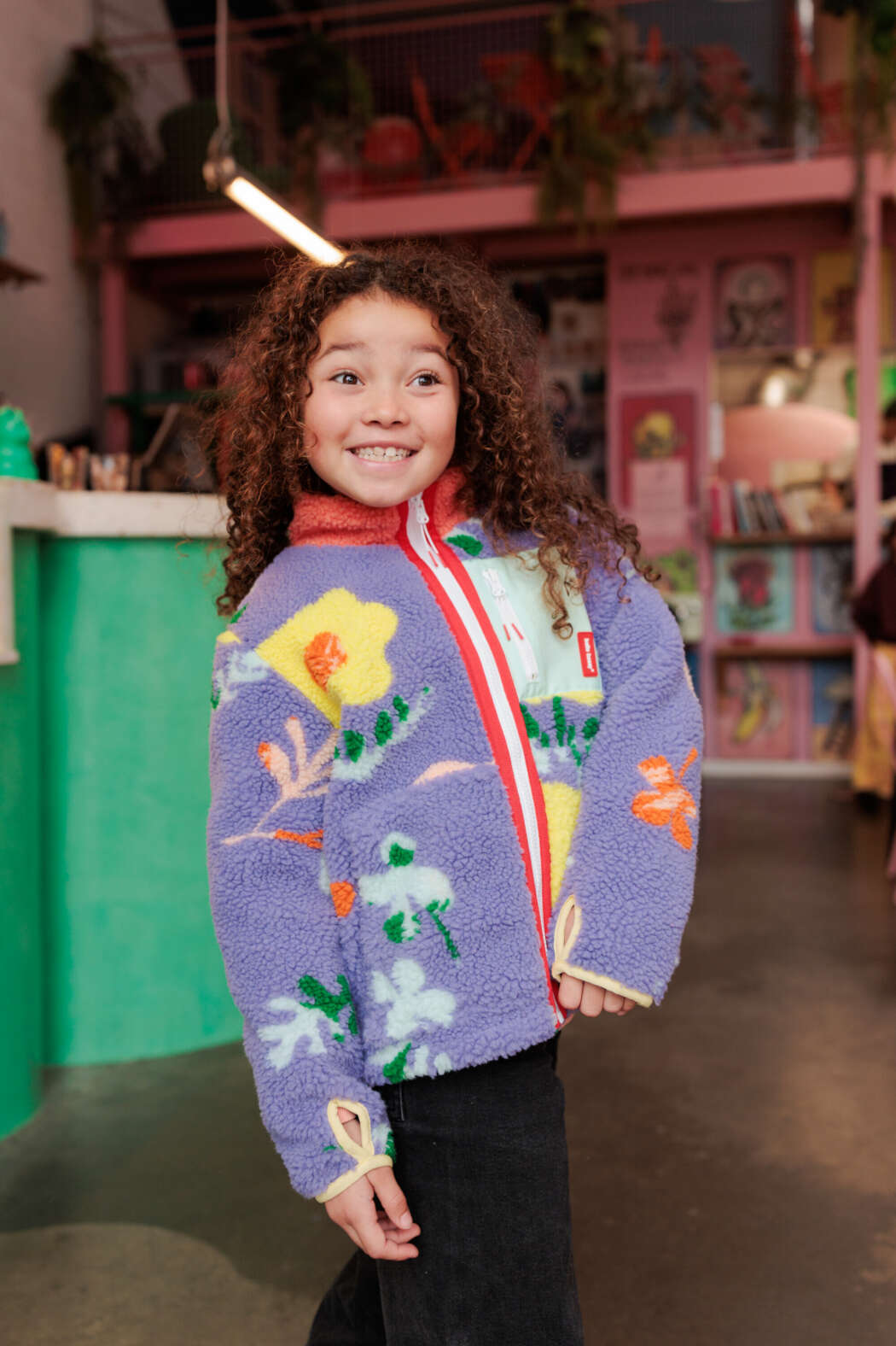 Kind draagt lila Floral Hello Hossy teddyjas met bloemenprint en fleece