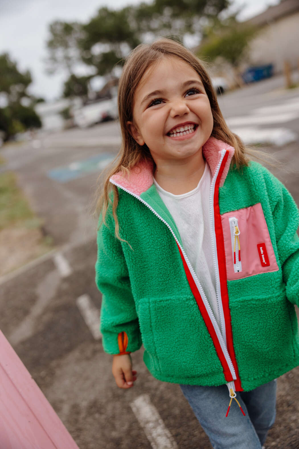 Kind draagt groene Green Candy Hello Hossy teddyjas met roze en fleece