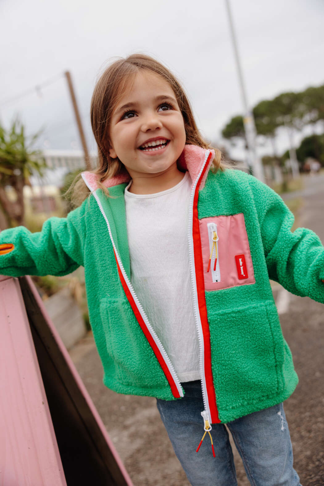 Kind draagt groene Green Candy Hello Hossy teddyjas met roze